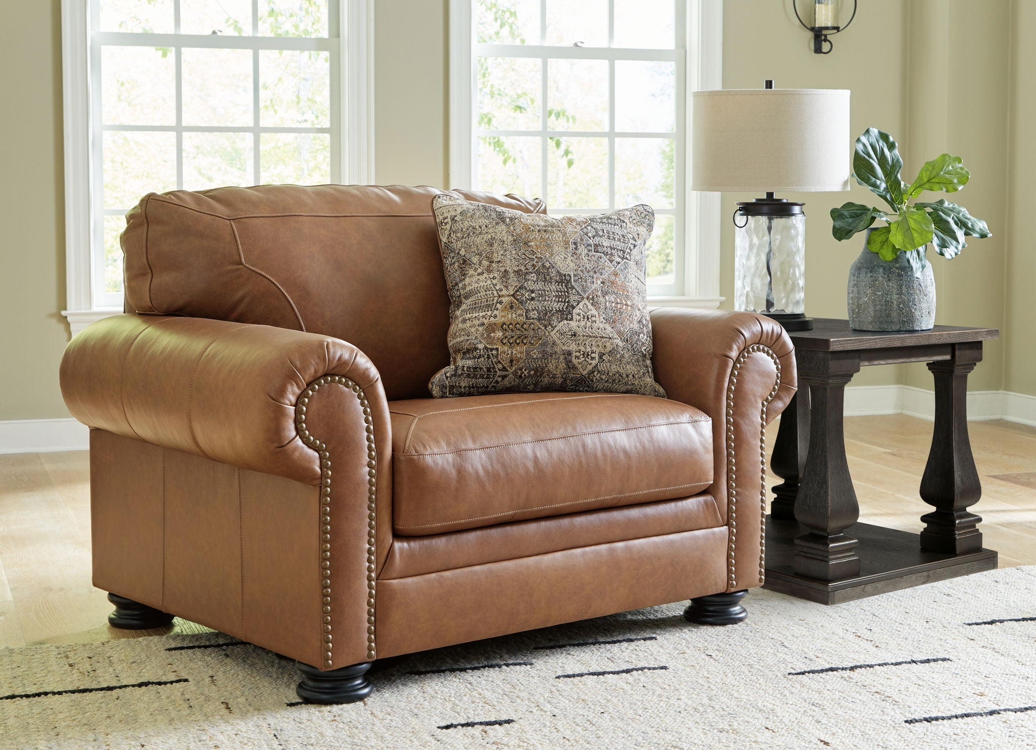 Brown armchair and matching ottoman with patterned pillow on the chair