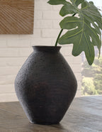 Dark ceramic vase with ribbed surface and rounded base