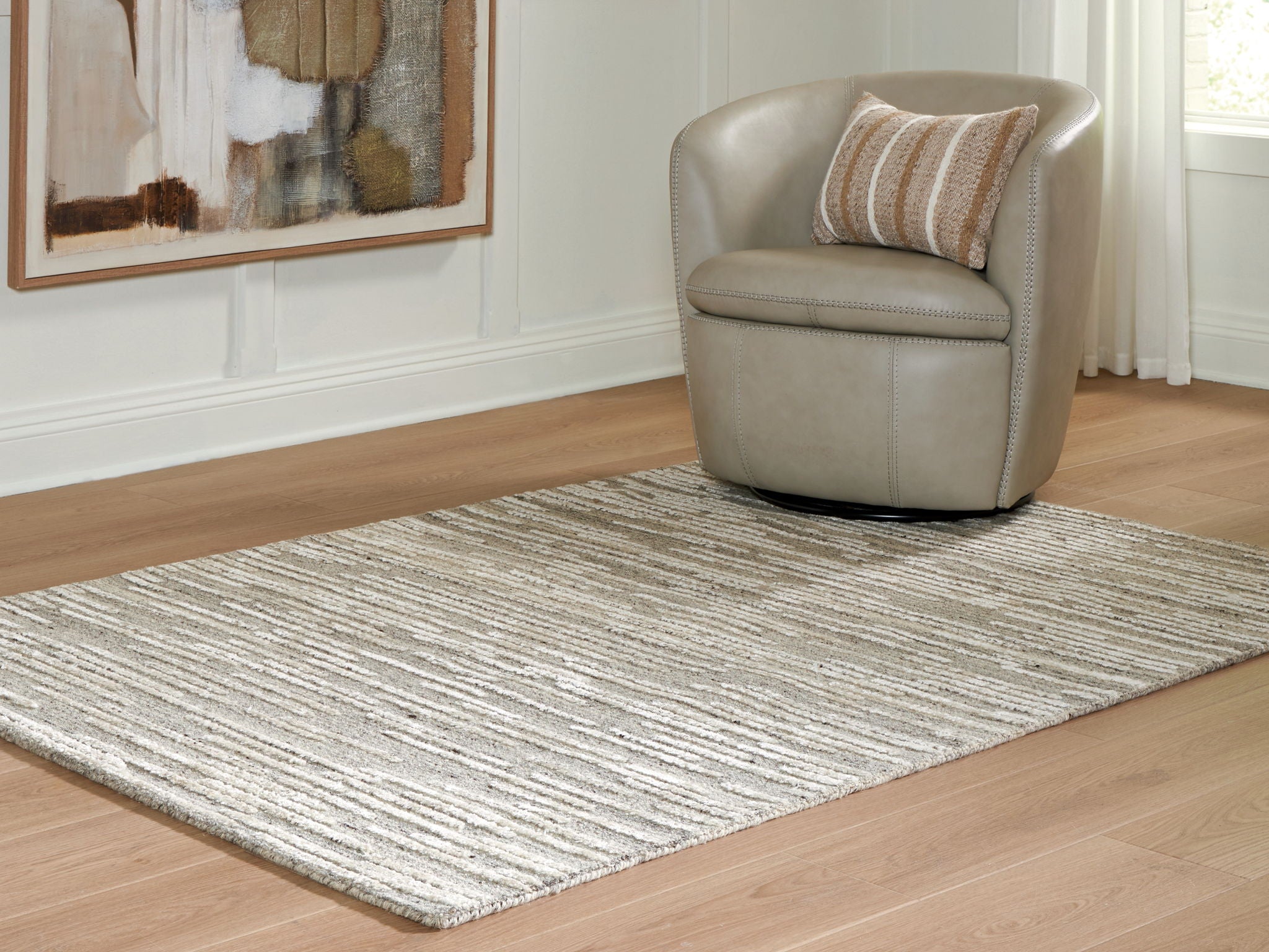 Gray striped area rug corner view with textured woven surface and low pile