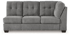 Gray fabric sofa with tufted back, three seat sections, and rounded right arm