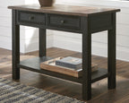 Grayish brown sofa table with two drawers and lower shelf holding stacked books