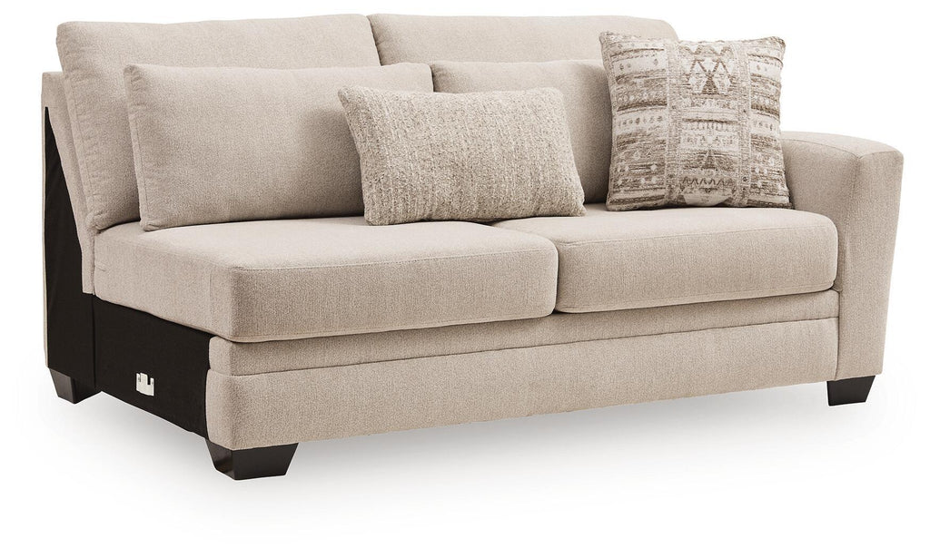 Beige fabric loveseat with boxy arms, two seat cushions, black legs, and three pillows.