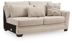 Beige fabric loveseat with boxy arms, two seat cushions, black legs, and three pillows.