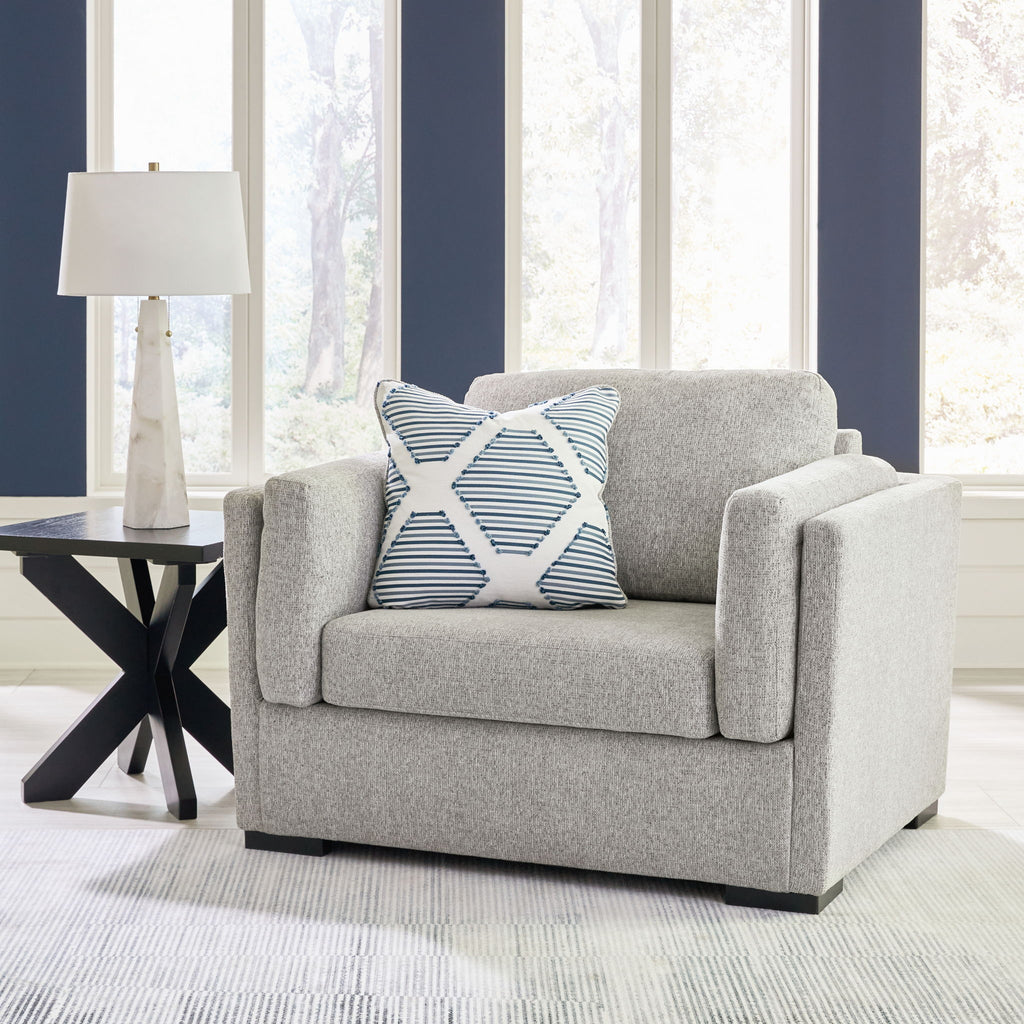 Light gray upholstered chair with two striped accent pillows