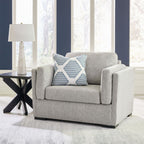 Light gray upholstered chair with two striped accent pillows