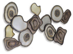 Multi-piece wall decor featuring assorted resin discs with concentric rings, white, tan, brown