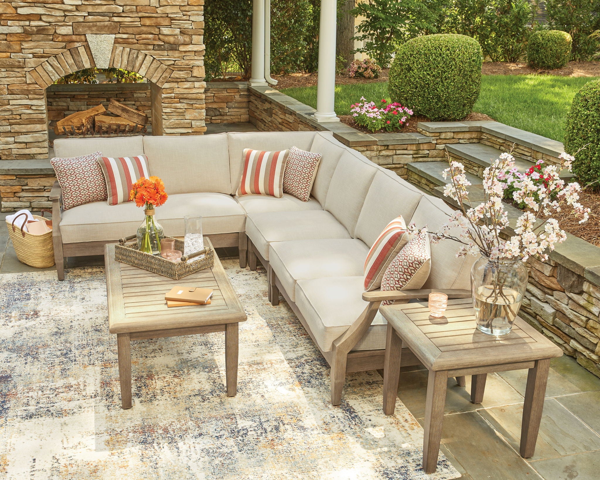 Beige outdoor sectional sofa corner with striped pillows and patterned accent cushions