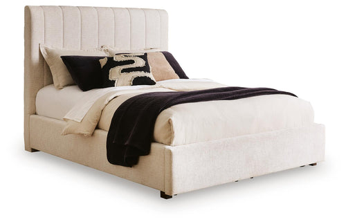 Beige upholstered queen bed with vertical channel headboard and padded frame, white bedding