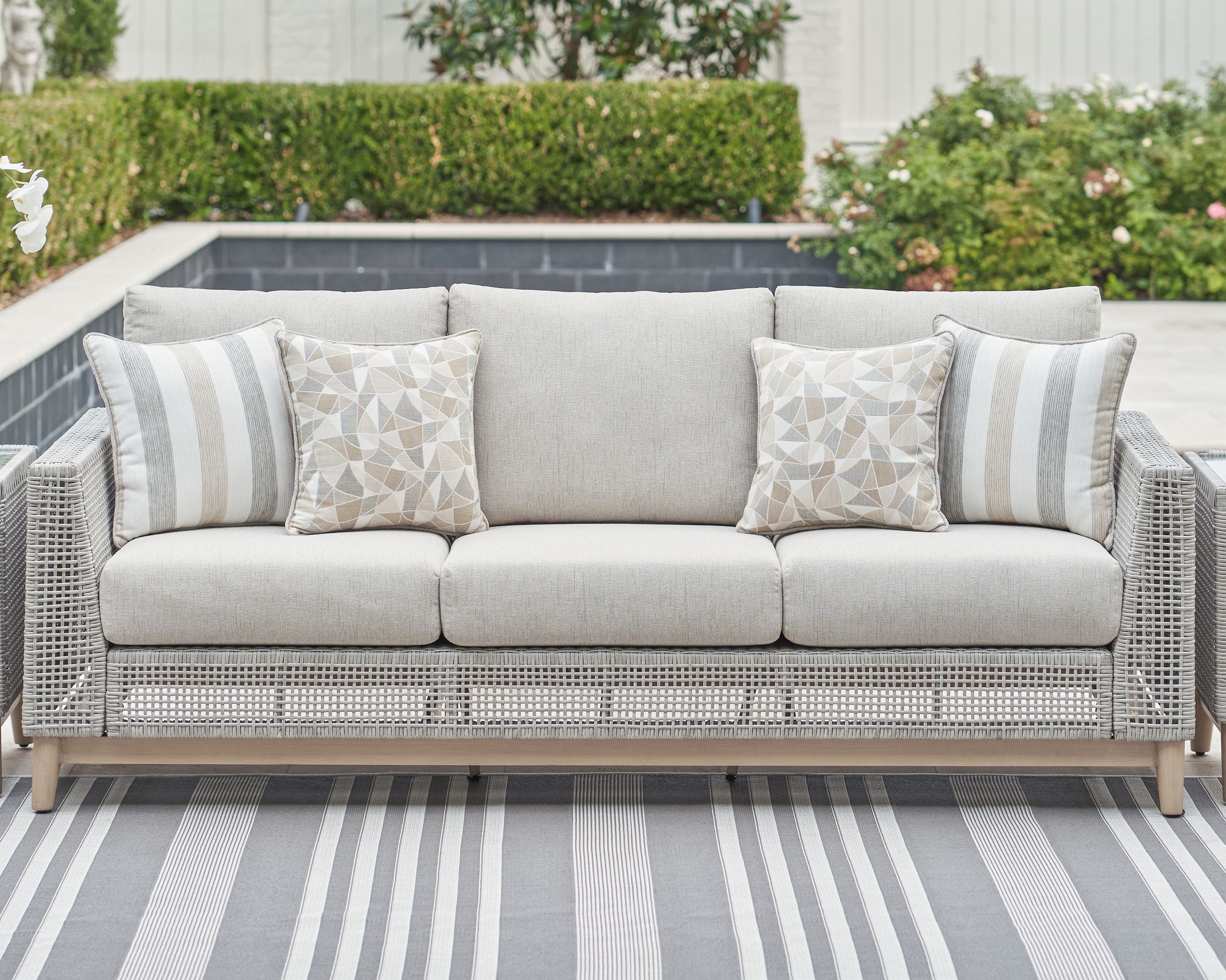 Gray woven sofa with cushions and four geometric throw pillows