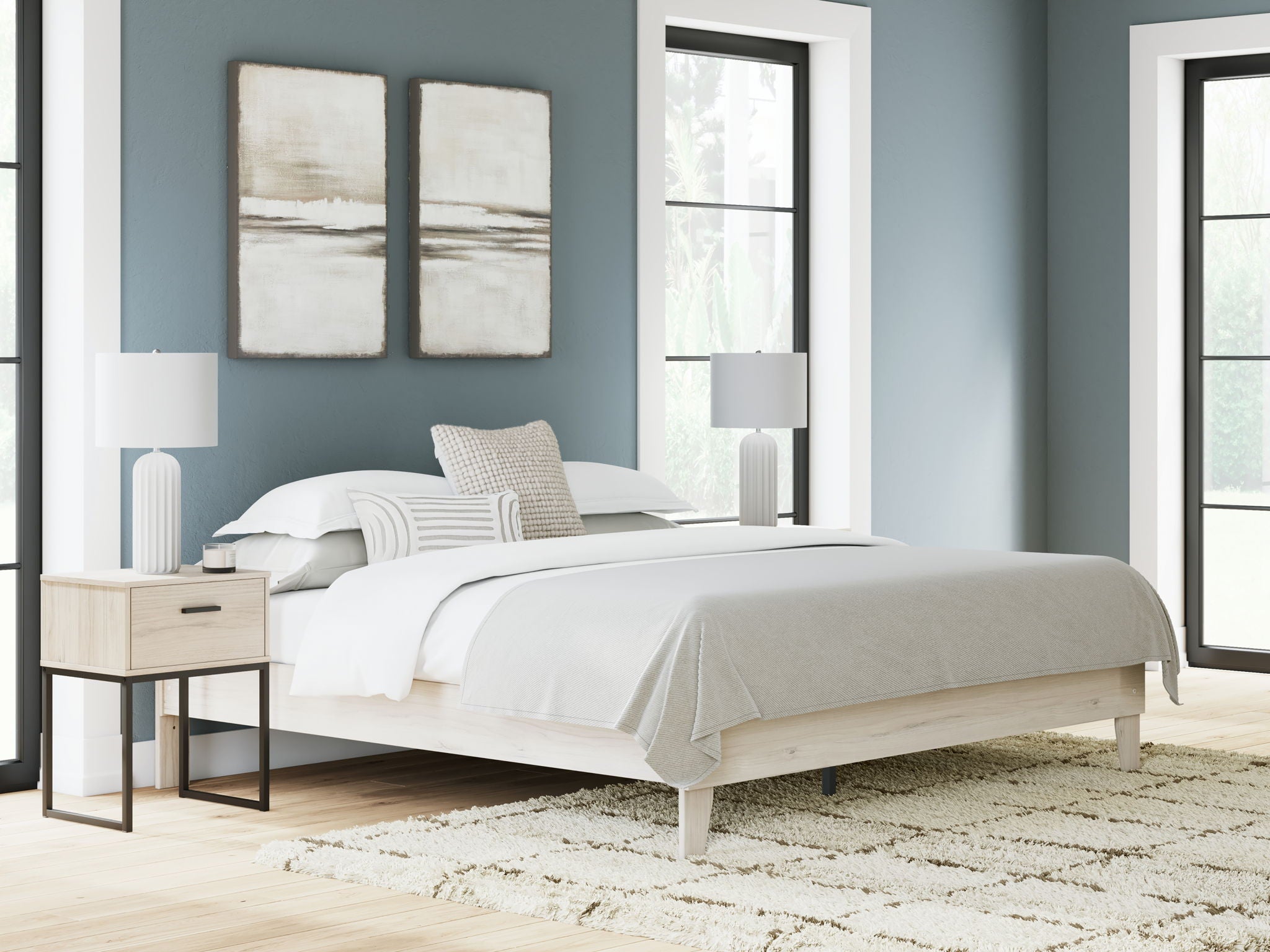 Platform bed with light wood frame and white bedding, raised base and slatted support