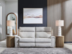 Reclining sectional sofa in light gray fabric with padded headrests and chaise