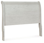 Antique white sleigh headboard with carved trim and textured wood panel