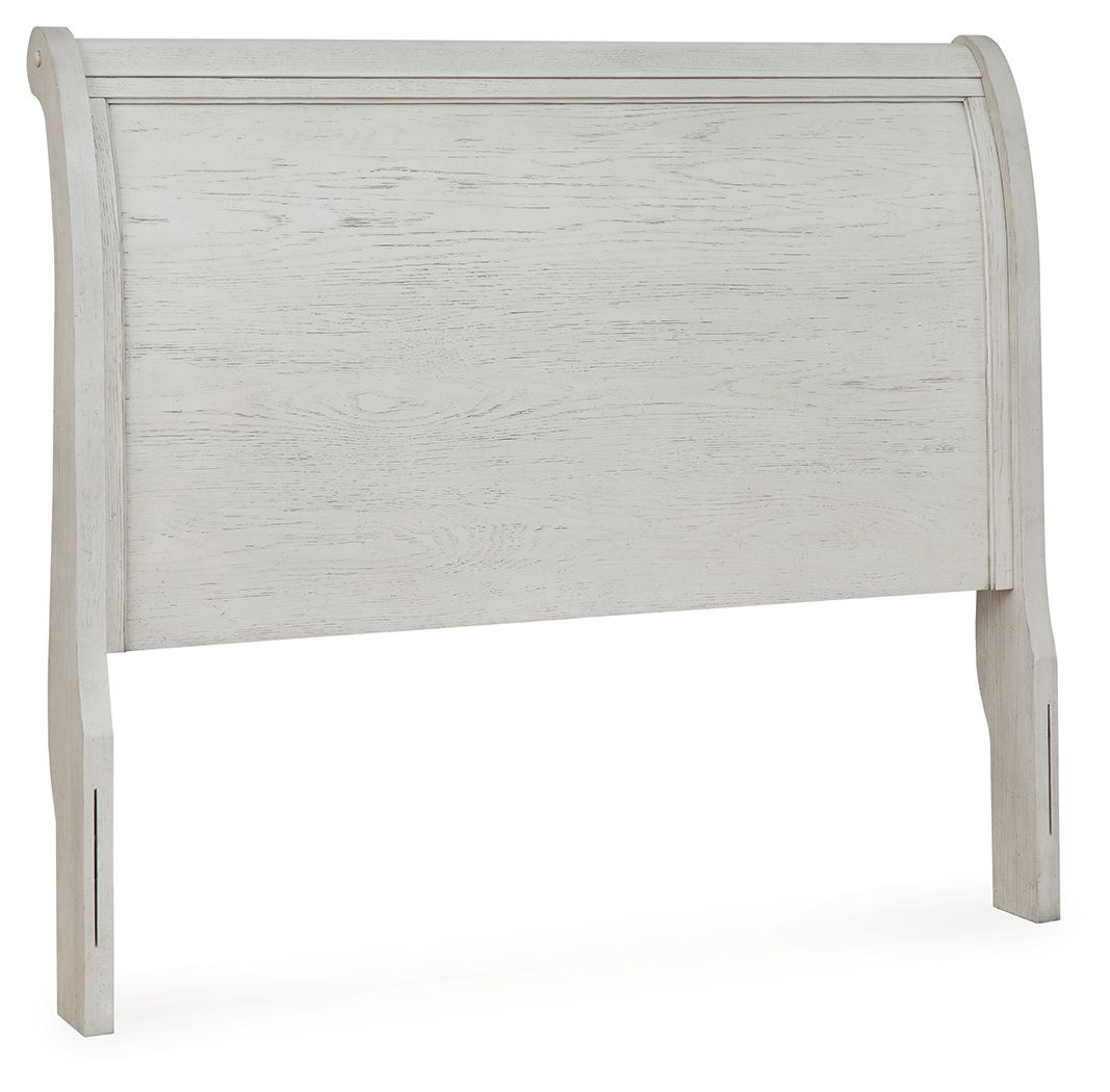 Antique white sleigh headboard with carved trim and textured wood panel