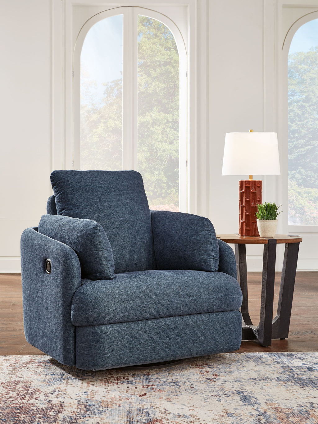 Swivel glider recliner chair in dark blue fabric with reclined seat and headrest.