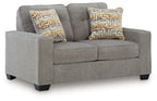 Gray upholstered loveseat with two seat cushions and patterned accent pillows