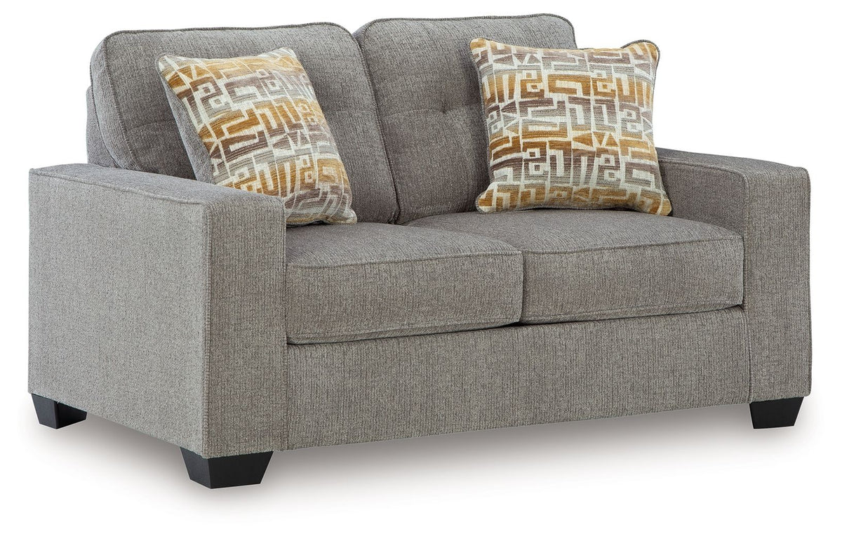 Gray upholstered loveseat with two seat cushions and patterned accent pillows