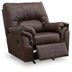 Dark umber upholstered rocker recliner with ottoman extended and tufted backrest