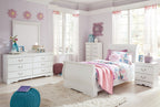 White sleigh bed set in a bright bedroom with matching dressers and mirror