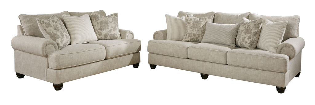 Two light gray upholstered seating pieces with patterned accent pillows