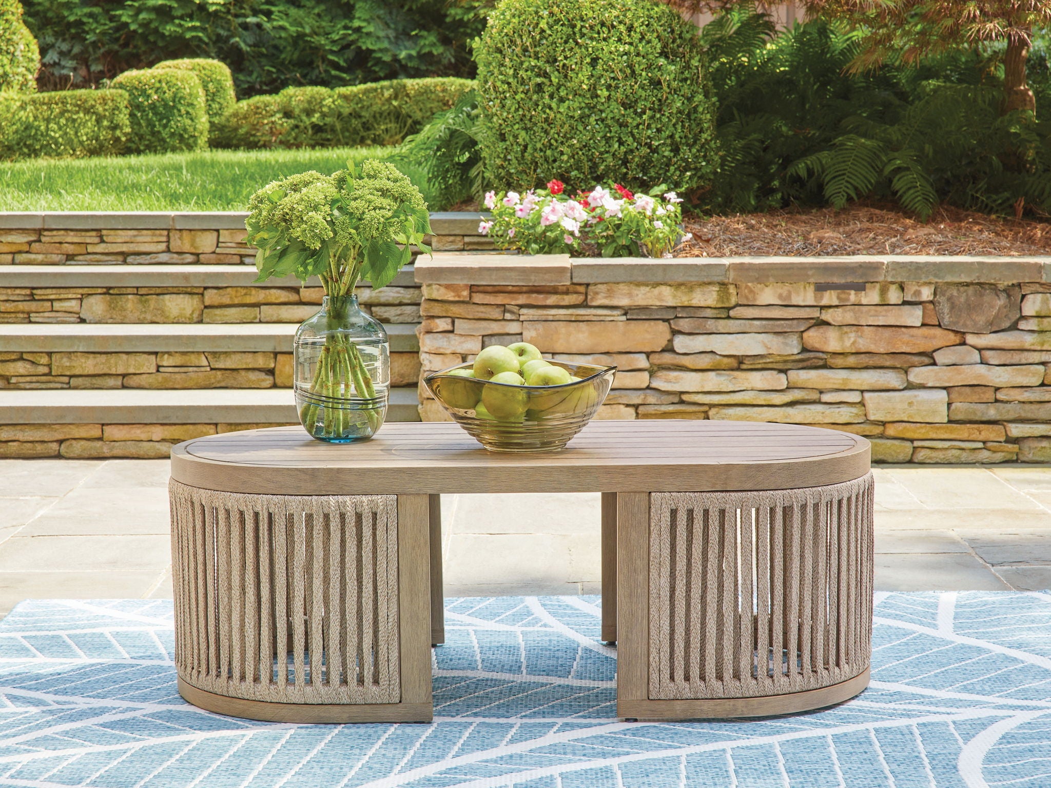 Beige round cocktail table with slatted sides, outdoors