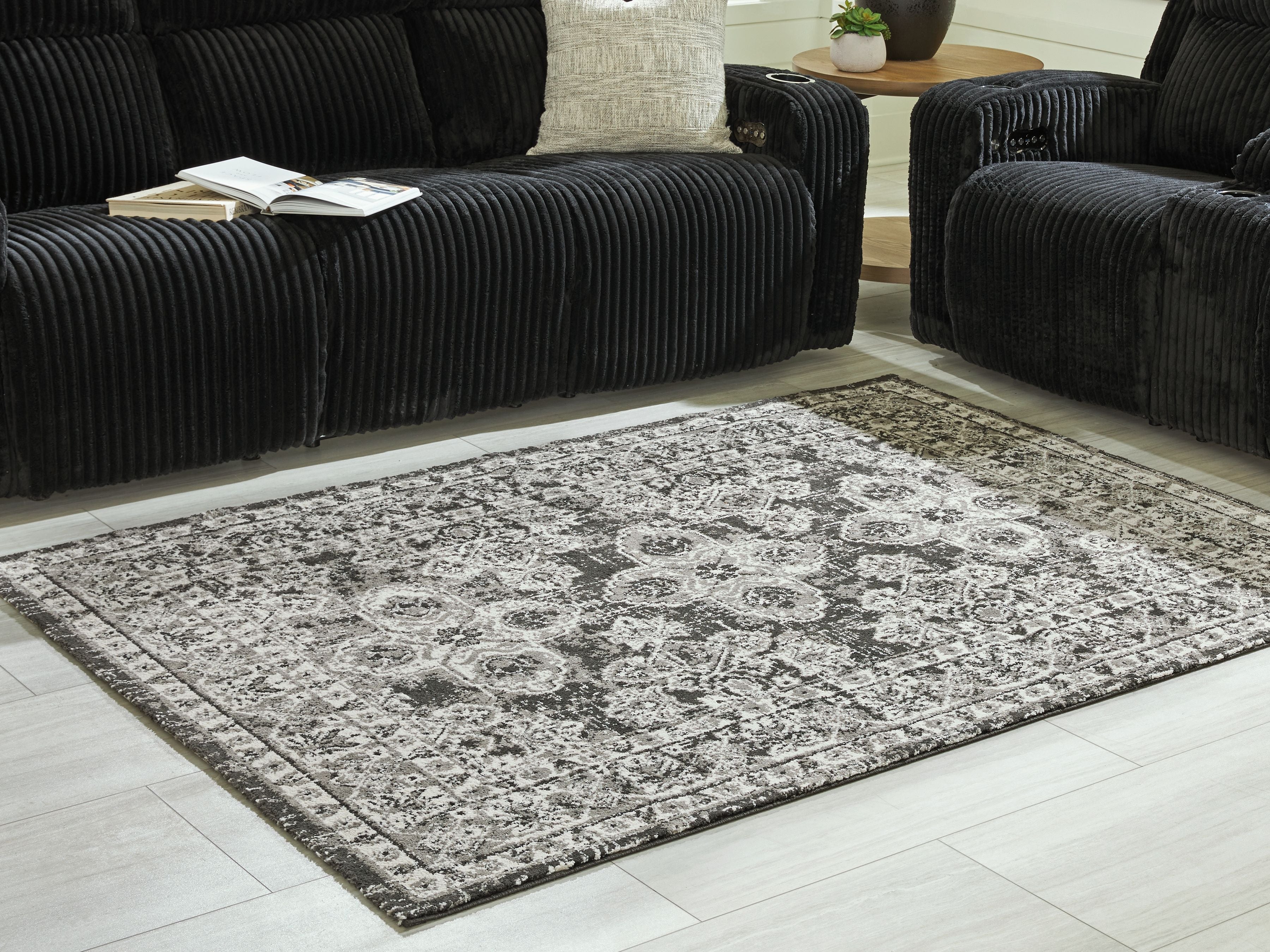 Glennisman rug on floor, large rectangular distressed pattern in light gray and black border
