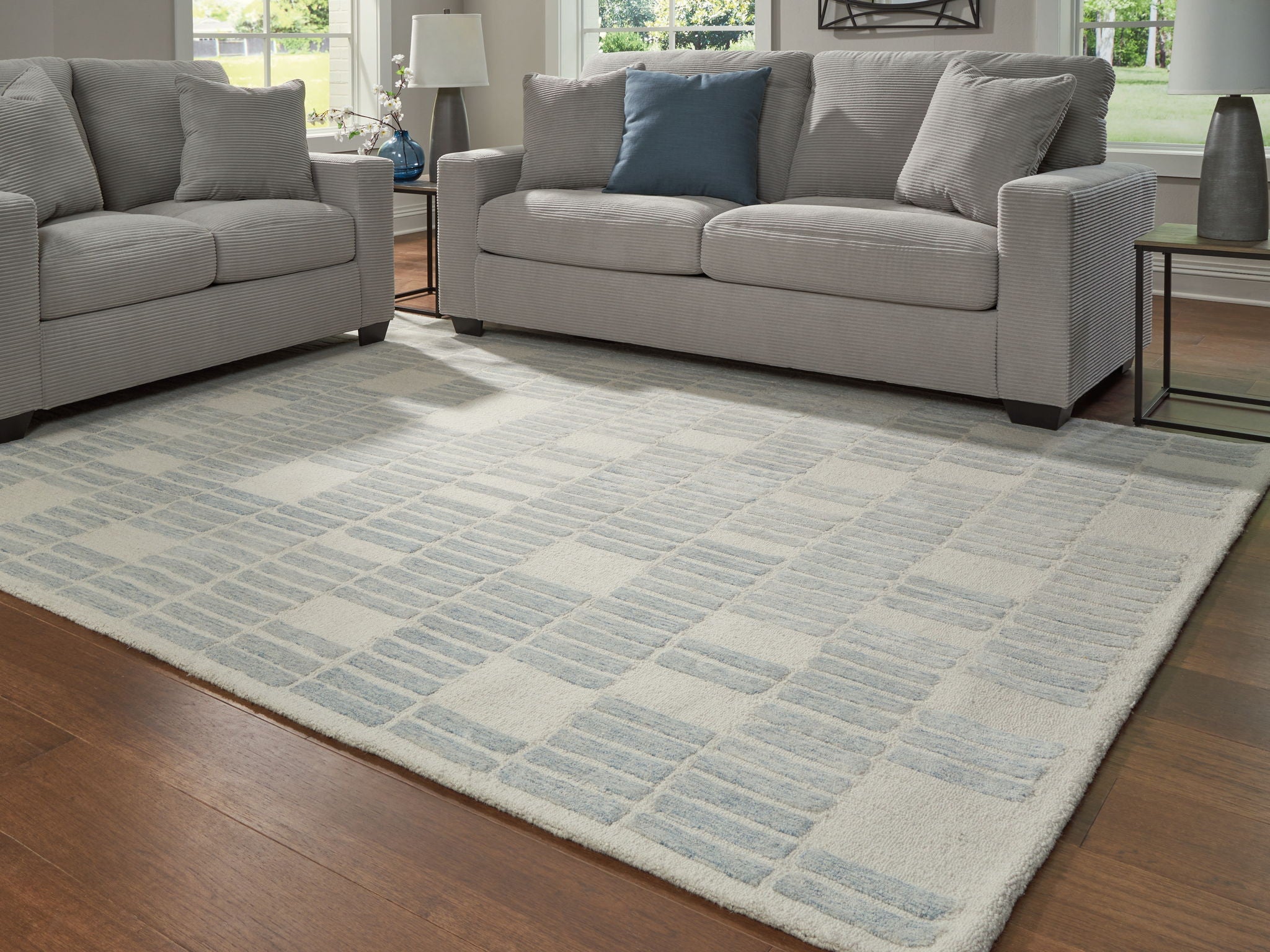 Light blue area rug with repeating grid pattern, rectangular shape on floor