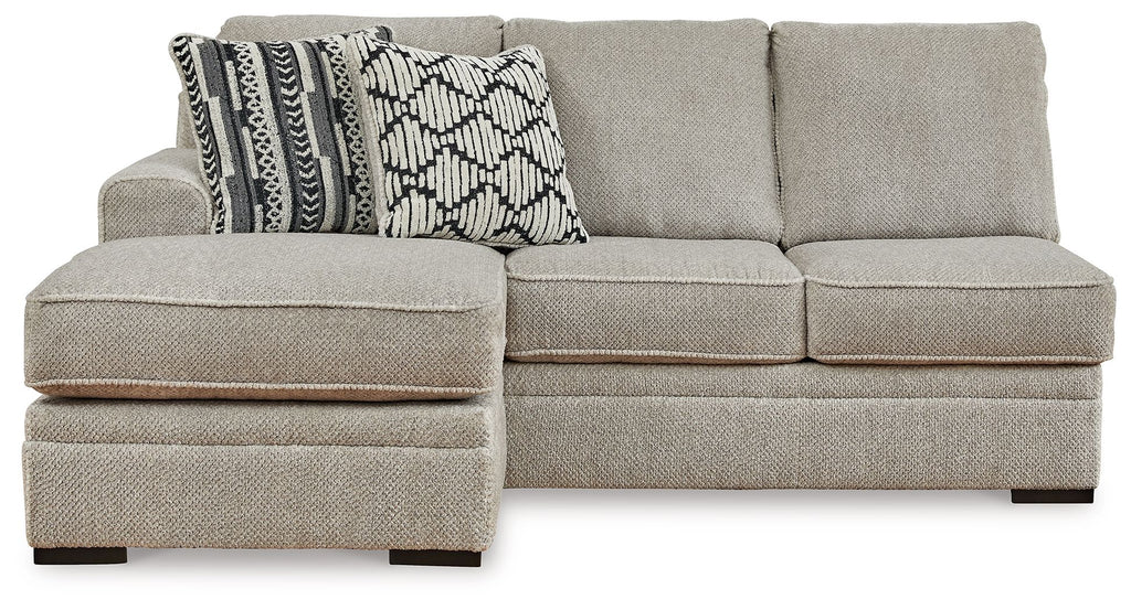 Light gray sofa chaise with square arms and two-tone geometric patterned throw pillows