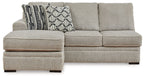 Light gray sofa chaise with square arms and two-tone geometric patterned throw pillows