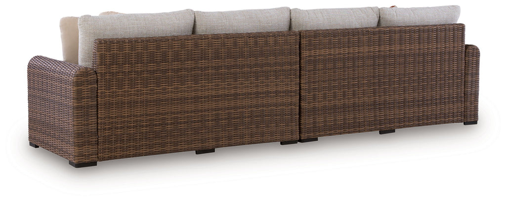 Outdoor loveseat set with brown woven frame and beige back cushions