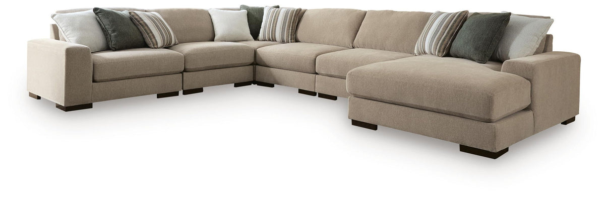 Light brown sectional sofa with chaise end and dark striped decorative pillows