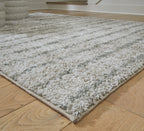 Cream and green rug corner with dense textured pile and flat stitched edge