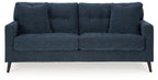 Blue upholstered sofa with three seat cushions and tall back pillows