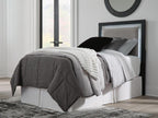Light gray upholstered panel headboard with dark frame, holding pillows and bedding.