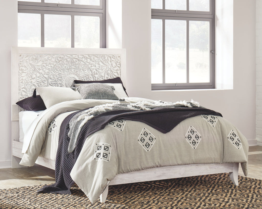 Whitewash queen panel headboard with upholstered white bed and patterned bedding