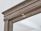 Light grayish brown mirror frame with top trim and small built-in light