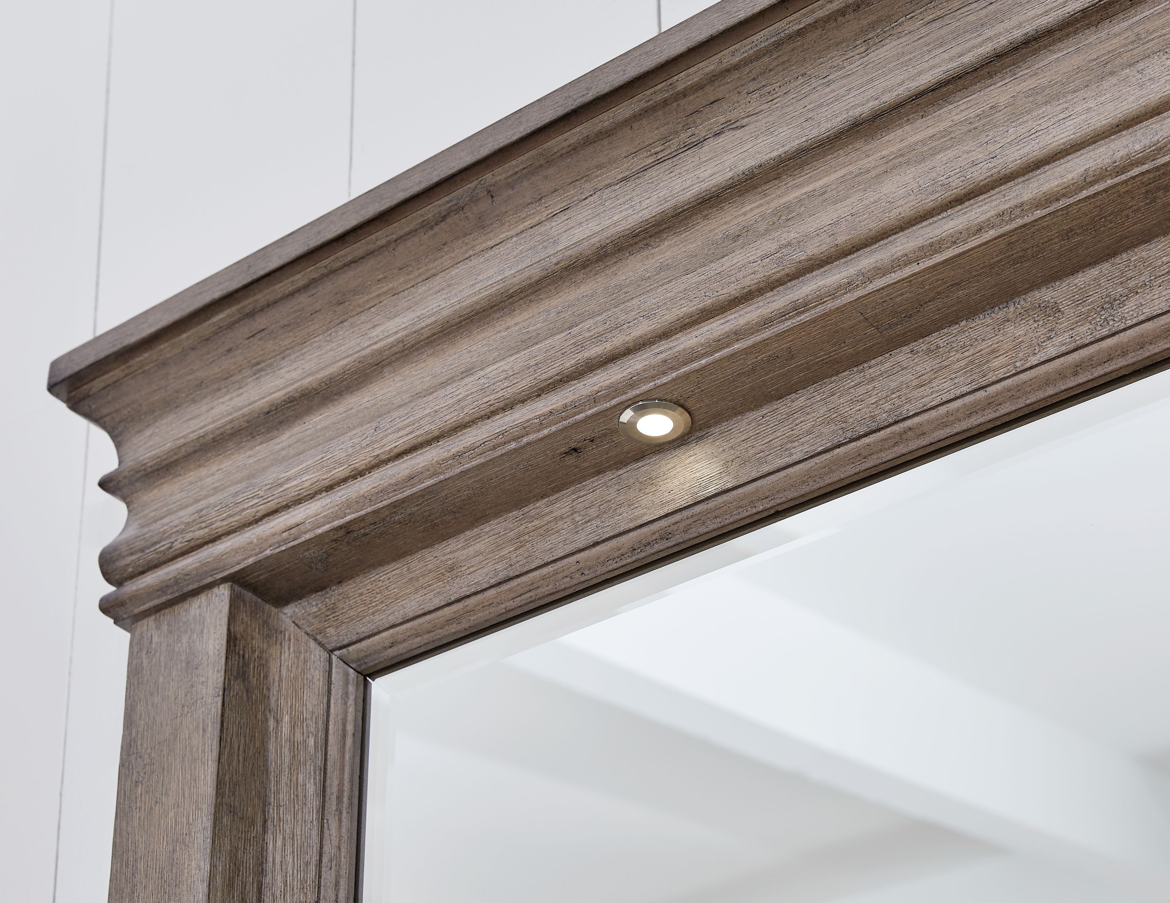 Light grayish brown mirror frame with top trim and small built-in light