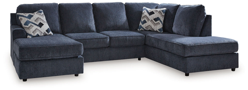 Blue sectional sofa with two ottoman benches and patterned accent pillows