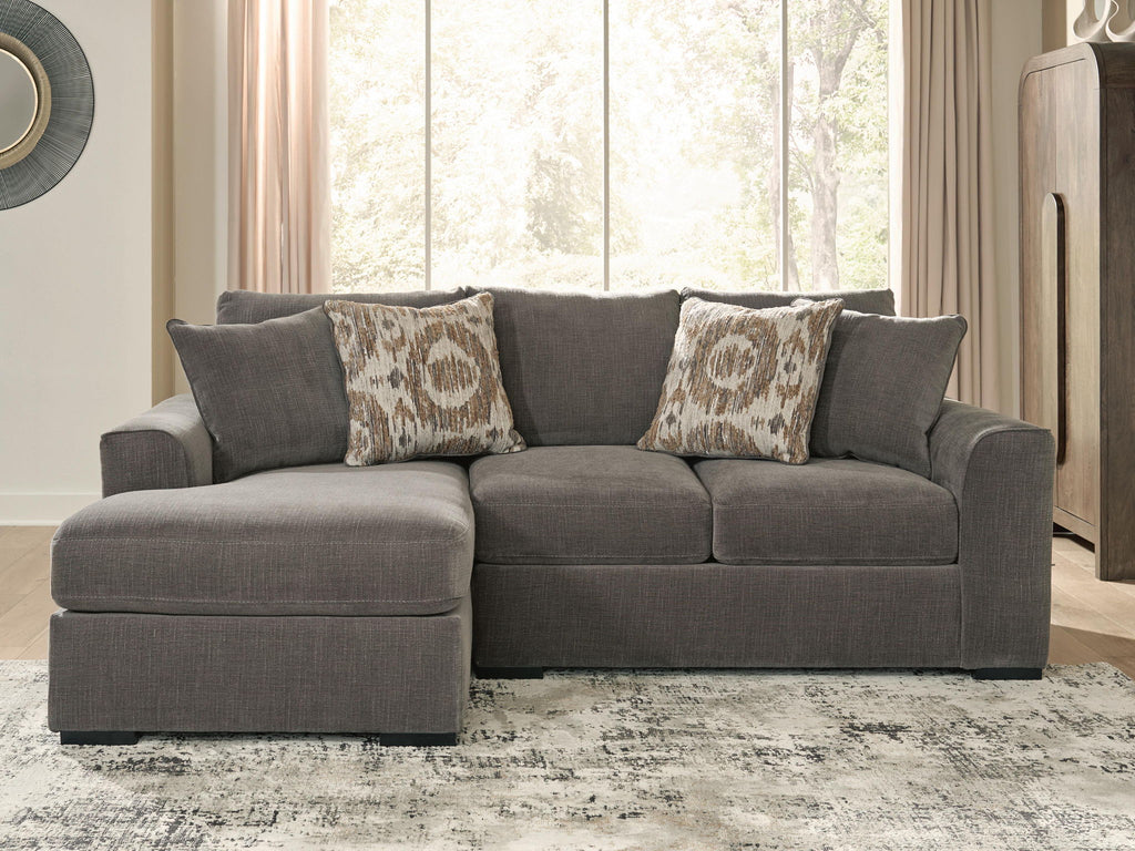 Gray sectional sofa with chaise cushion and two patterned throw pillows