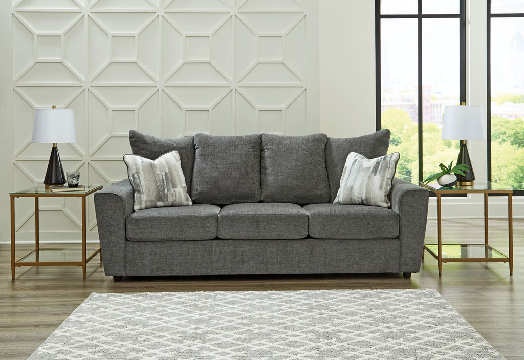 Dark gray fabric loveseat with three seat cushions and decorative throw pillows.