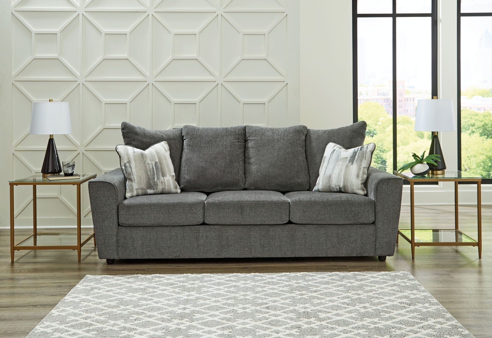 Dark gray fabric loveseat with three seat cushions and decorative throw pillows.