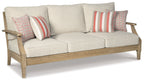 Beige sofa with three seat cushions and four decorative pillows