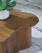 Brown accent cocktail table with oval-like rounded top and carved curved base