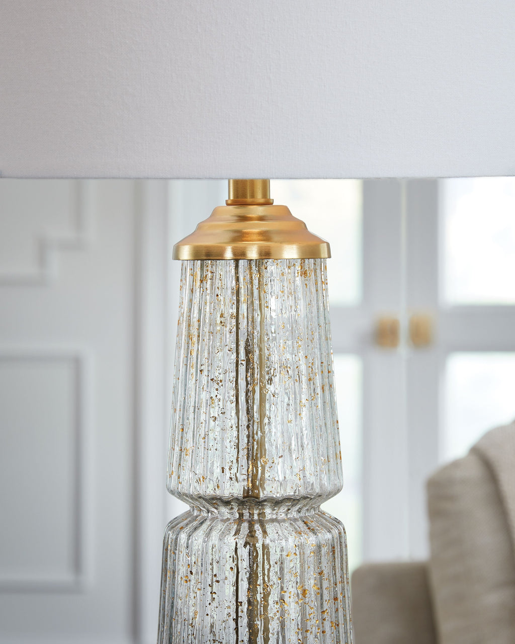 Glass table lamp with clear textured glass body and gold metal cap and base