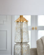 Glass table lamp with clear textured glass body and gold metal cap and base