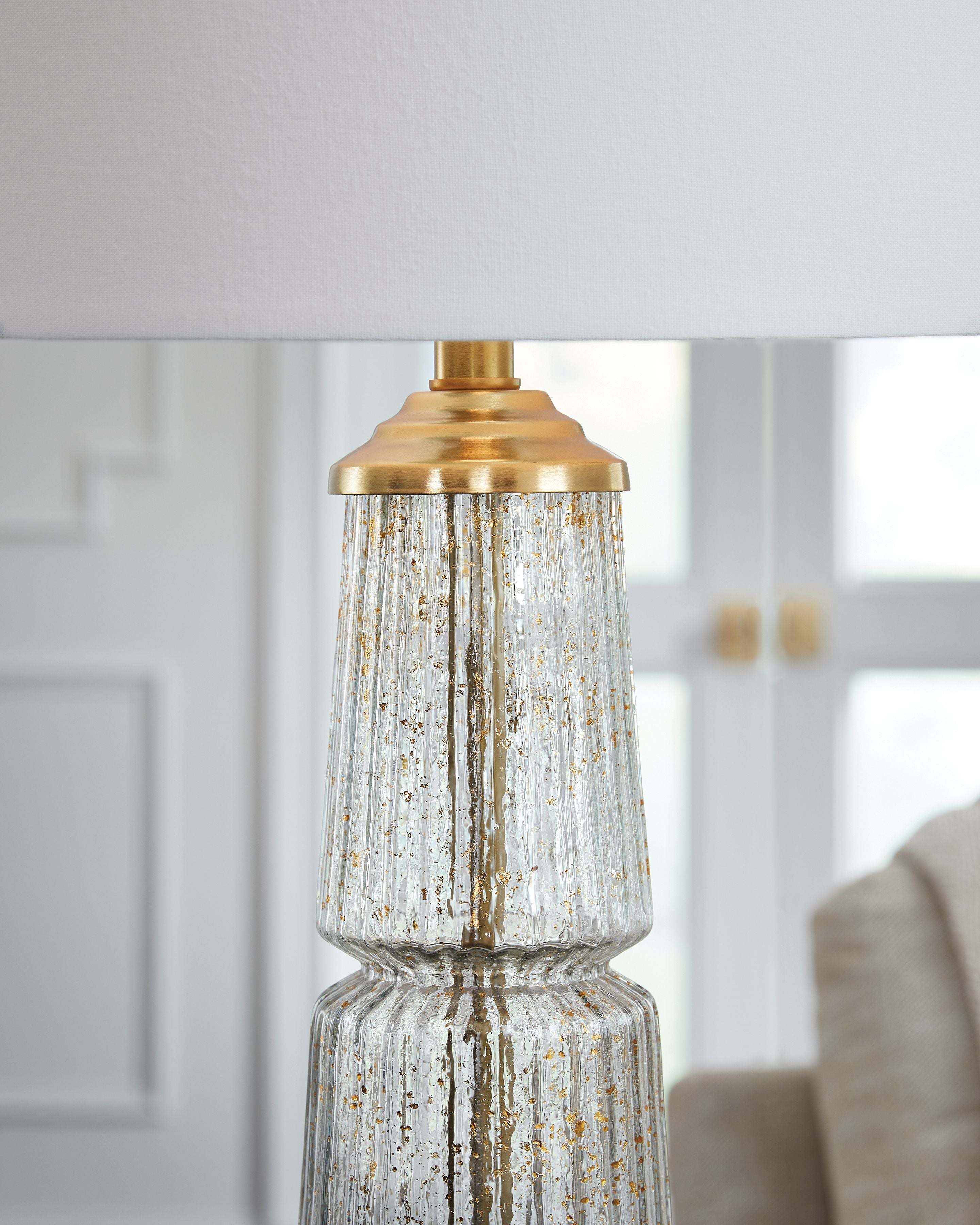 Glass table lamp with clear textured glass body and gold metal cap and base