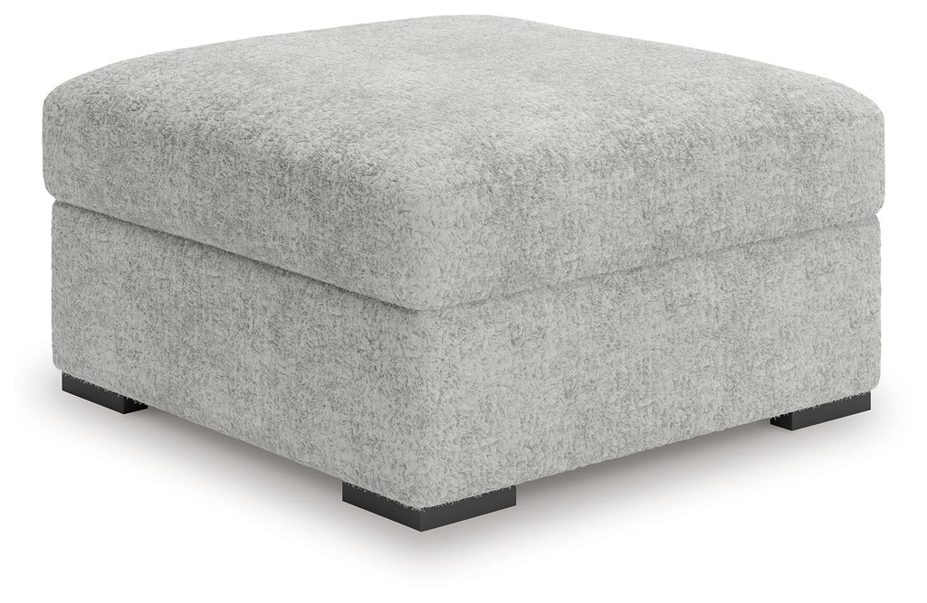 Light gray oversized accent ottoman with low black feet and squared profile