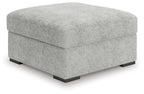 Light gray oversized accent ottoman with low black feet and squared profile