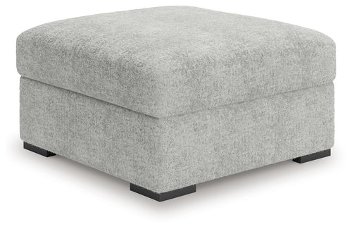 Light gray oversized accent ottoman with low black feet and squared profile
