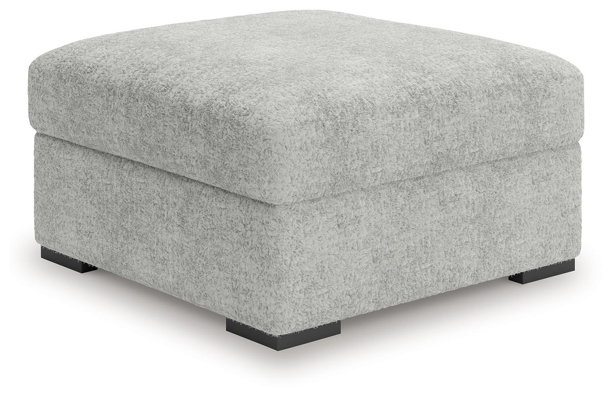 Plush ottoman cube with textured light gray upholstery and black tapered legs