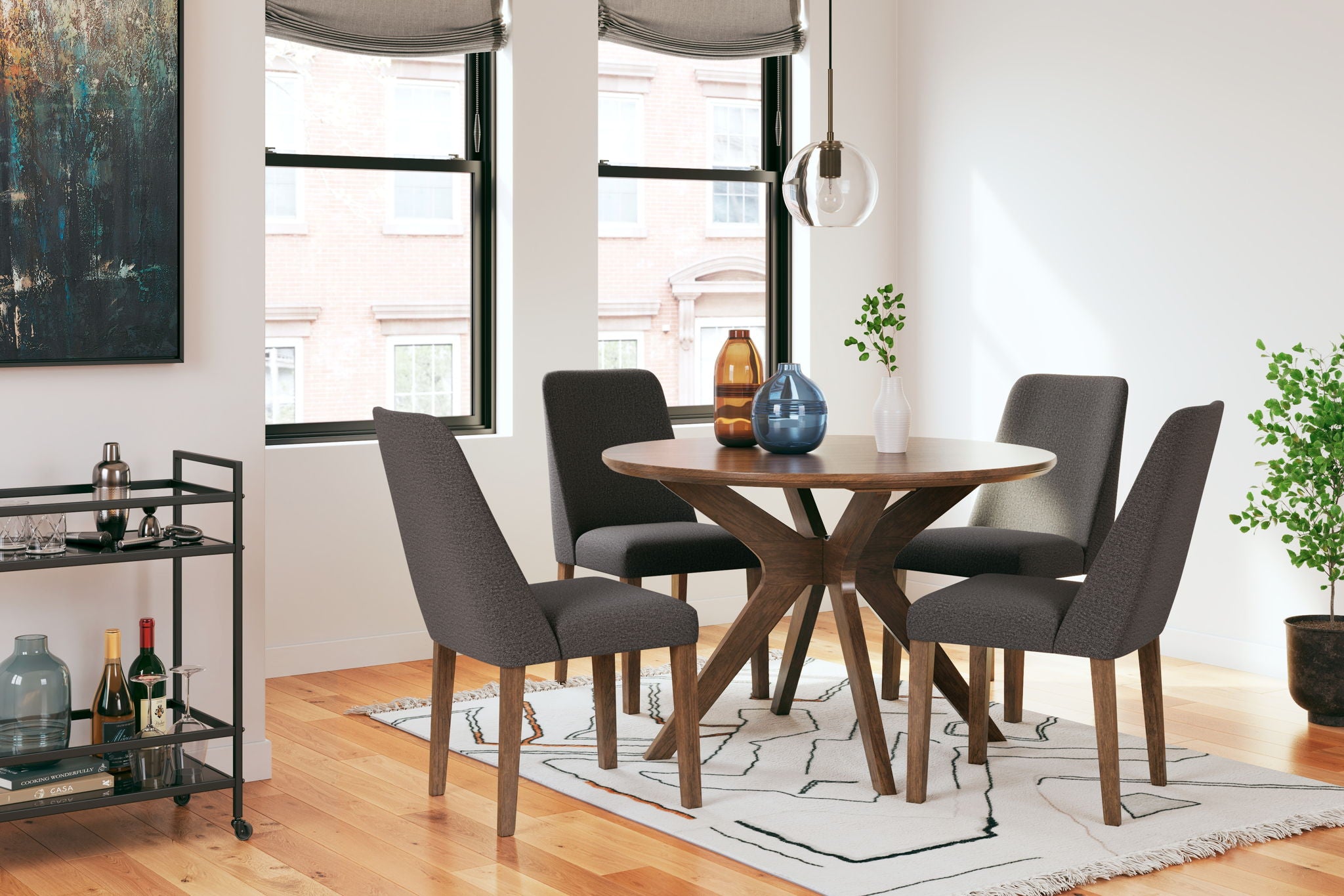 Dining table set with round wood table and four dark gray upholstered chairs